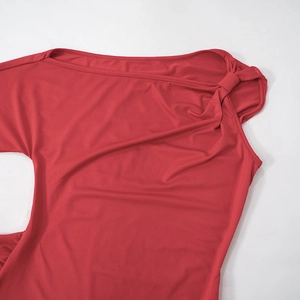 Détail de la robe en tricot rouge montrant l'encolure asymétrique et le nœud à l'épaule