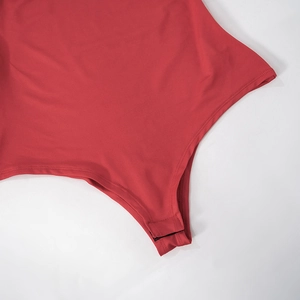 Gros plan détaillé de la couture de l'entrejambe du body rouge et du tissu élastique