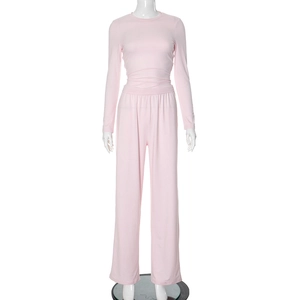 Detail view of light pink two-piece set featuring long sleeve top and wide leg trousers