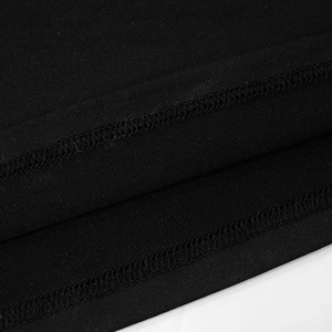 Gros plan détaillé sur les doubles coutures soignées de l'ourlet de la robe en tricot noir