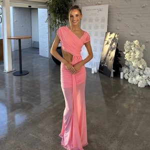 Detail of pink one-shoulder dress showing waist cutout and side draped ruffle textures
