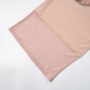 Dettaglio delle cuciture e della stampa floreale sull'abito lungo in maglia rosa