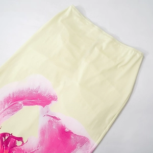 Detailed view of pale yellow satin skirt featuring a large bright pink floral print