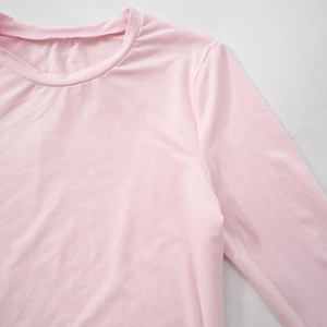 Detail of soft pink long sleeve top showing fine ribbed texture and round neckline finish