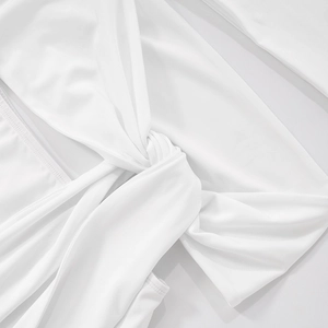 Detailed view of the knotted fabric and fine stitching on a white off-shoulder mini dress