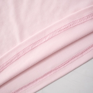 Detailed close-up of pink knit fabric showing high-quality double stitching and texture