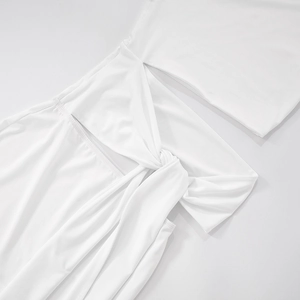 Close-up of white summer dress featuring cut-out waist design and knot detail texture