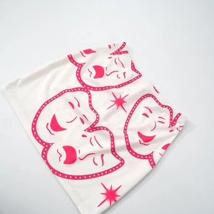 Detail of white ribbed knit mini skirt featuring artistic pink mask print and soft texture