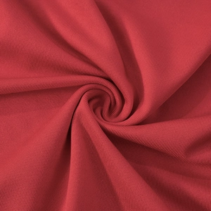 Vue macro détaillée du tissu en maille côtelée rouge foncé avec une texture verticale douce