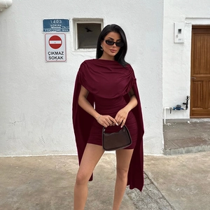 Detail of burgundy cowl neck mini dress with side ruching and cape shoulder design