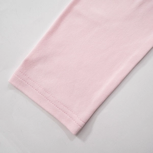 Detail view of pink knit garment featuring precise double-needle stitching on hem and cuff