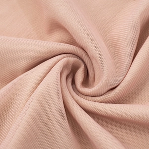 Vista macro dettagliata del tessuto a rete rosa fine con trama a nido d'ape e drappeggio