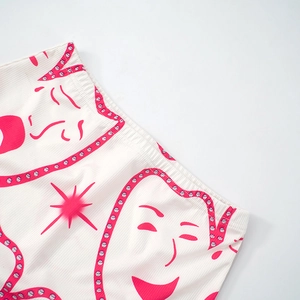 Detailed view of white ribbed knit shorts featuring fuchsia abstract face graphic print