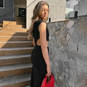 Detail of elegant black sleeveless dress featuring side cut-outs and ruched waist details