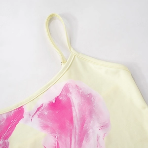 Close-up of elegant floral print on slim yellow summer top with thin spaghetti straps