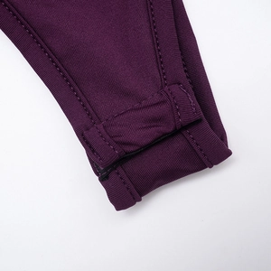 Detail of dark purple ribbed knit bodysuit featuring snap button closure and clean stitching