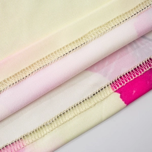 Close-up of overlock stitching and floral print fabric on the elegant two-piece set