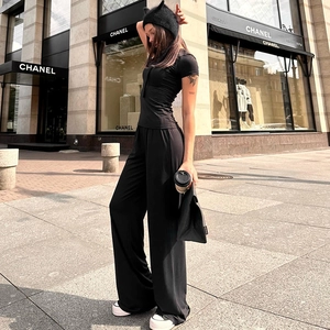 Detail of high-waisted black wide-leg pants and slim-fit top with premium draped texture