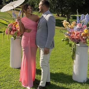 Close-up of pink one-shoulder dress featuring side waist cutout and ruched fabric detail