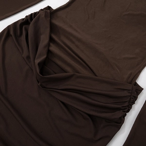 Detailed macro view of dark brown ruched fabric with stretch texture on this dress