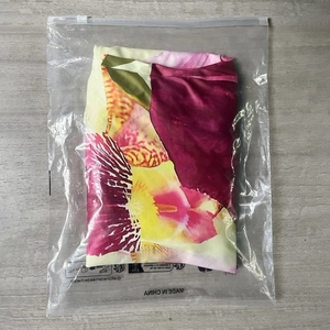 Detail of floral printed fabric set packaged in a clear zip bag on a wooden background