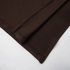 Detail of professional double-needle stitching on dark brown knit fabric dress