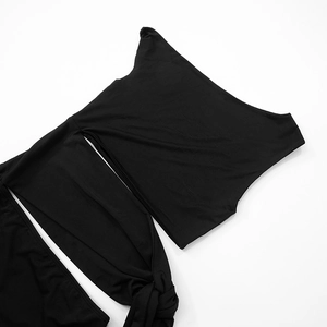 Detail of black off-shoulder bikini top with wrap-around tie waist detail on white background