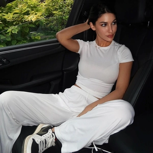Detail of white long sleeve T-shirt and high waist wide leg pants set in car interior