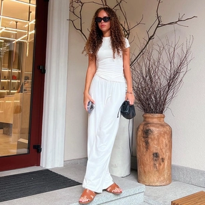 Detailed close-up of white minimalist lounge set with wide-leg trousers and crew neck top