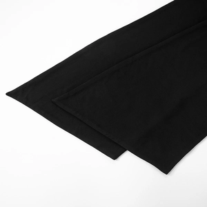 Detail of black knit fabric showing the clean hem and precise double-layered stitching