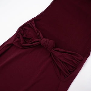 Détail de la robe bustier bordeaux avec un nœud élégant et une texture plissée fluide