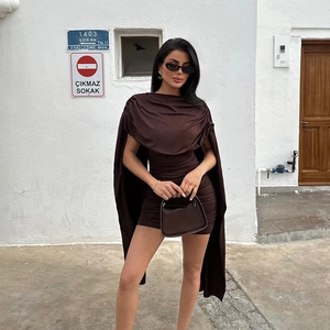 Detail of dark brown ruched mini dress featuring a sleek cape and draped neckline