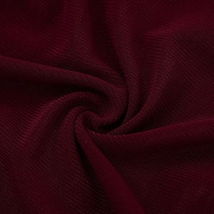 Gros plan macro de la texture du tissu en maille bordeaux foncé et de son drapé