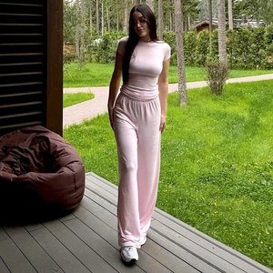 Outdoor close-up of pink long-sleeve top and elastic wide-leg trousers set in soft knit