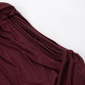 Detailed macro shot of burgundy ruched stretch fabric showing drape and texture