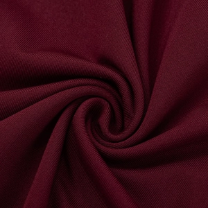 Gros plan sur le tissu en maille côtelée bordeaux élégant avec texture et drapé doux