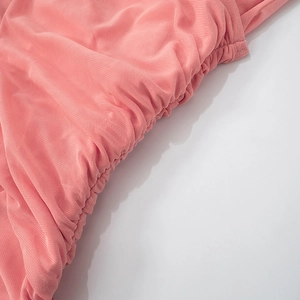Close-up of elegant pink ruched fabric detail with refined pleated texture and soft mesh