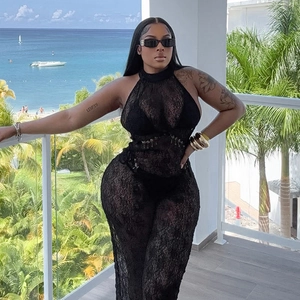 Close-up of black lace backless hollow dress on a balcony with seaside vacation background