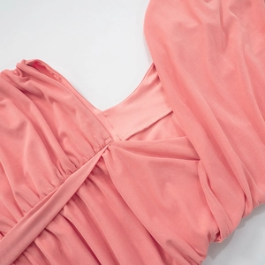 Detail of coral pink sleeveless dress showing deep V-neckline with pleated cross stitching