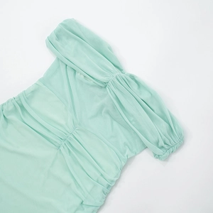 Close-up of mint green off-shoulder dress with textured mesh pleats and ruched details