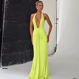 Close-up of ruched lime green maxi dress featuring a deep V-neck halter and smooth fabric