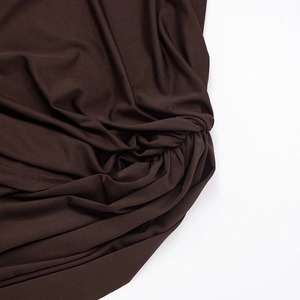 Detail of dark brown knitted fabric showing the elegant twist and draped pleat design