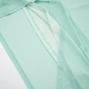 Close-up of mint green pleated fabric showing reinforced seams and smooth inner lining