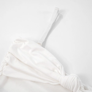 Détail des bretelles réglables et du bustier noué plissé sur une robe longue blanche