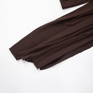 Detailed view of the dark brown fabric texture and hemline of the cowl neck dress