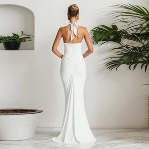 Detail view of white halter neck dress featuring backless tie-up design and ruched finish