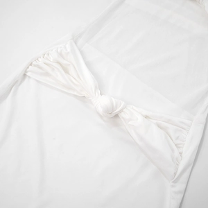 Gros plan détaillé d'une robe bustier blanche avec nœud torsadé et empiècements en maille
