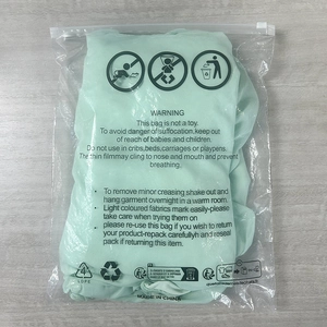 Mint green ruched tube dress folded in a transparent protective zip bag with safety warnings