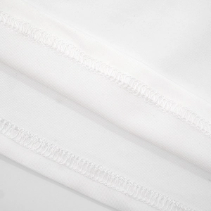 Gros plan sur la couture double aiguille et la texture du tissu tricoté de la robe blanche