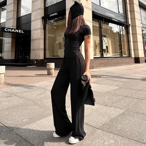 Close-up of high-waist wide-leg trousers and slim-fit top set in premium black fabric